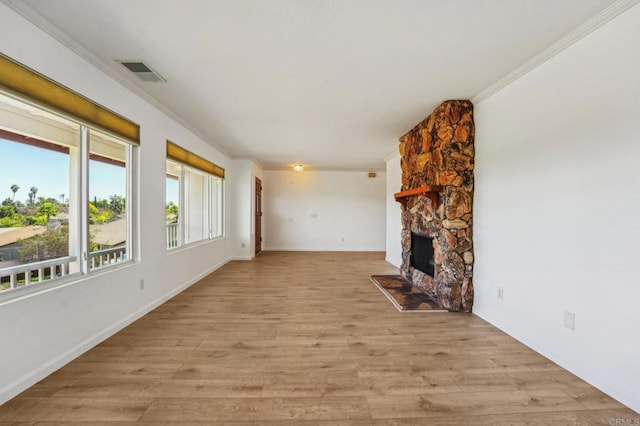 unfurnished living room featuring a fireplace, visible vents, baseboards, light wood finished floors, and crown molding