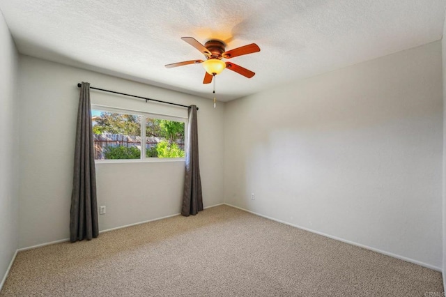 empty room with light carpet, ceiling fan, and a textured ceiling