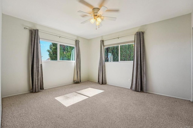 empty room with light carpet and a ceiling fan