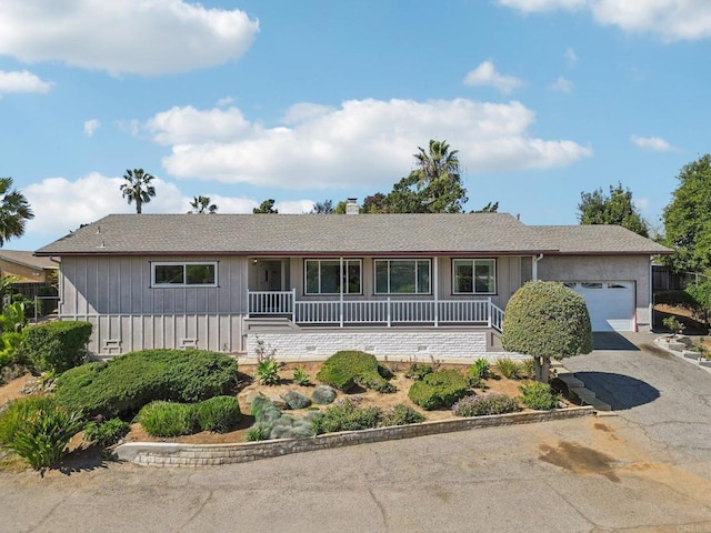 ranch-style house with a garage, aphalt driveway, and a chimney