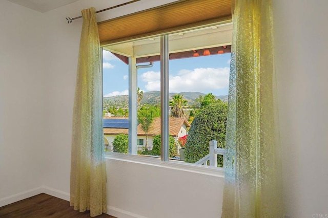 doorway to outside featuring baseboards, a mountain view, and dark wood-style flooring