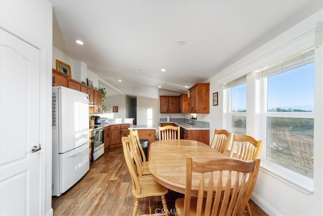 dining area with baseboards, wood finished floors, and recessed lighting