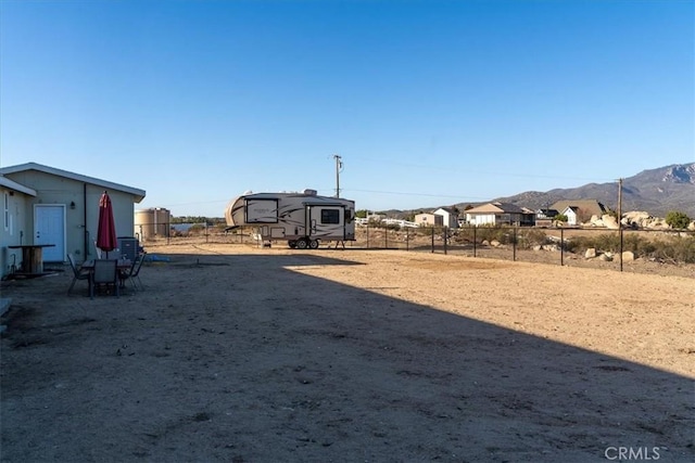 view of yard featuring a mountain view and fence