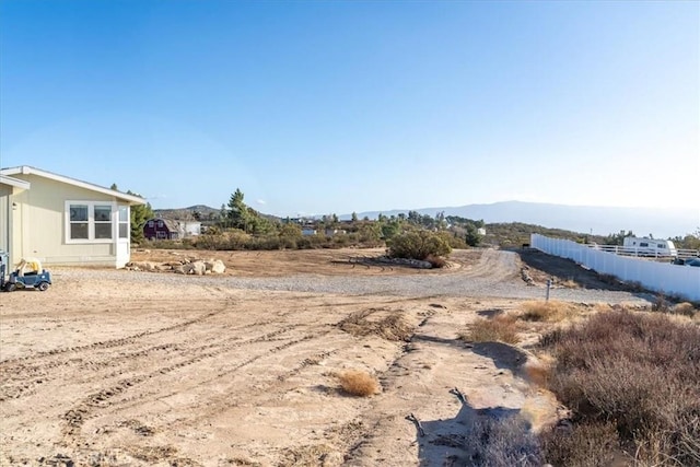 view of yard with fence and a mountain view