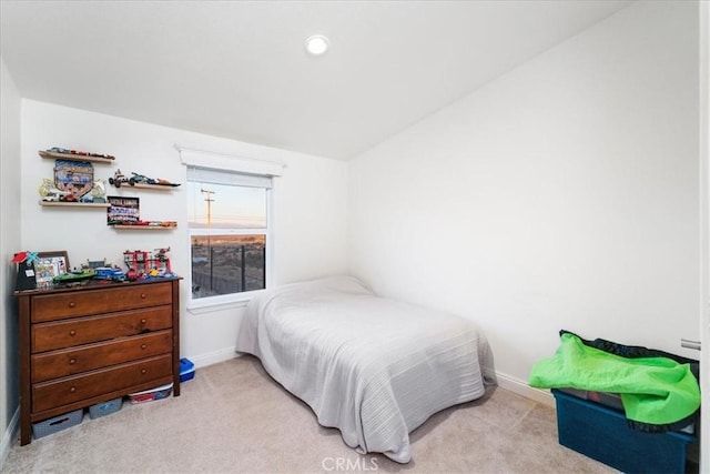 bedroom featuring light carpet and baseboards