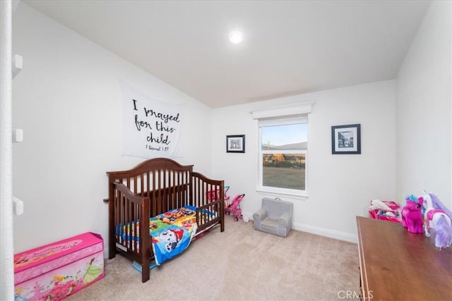 bedroom featuring carpet floors, a nursery area, and baseboards