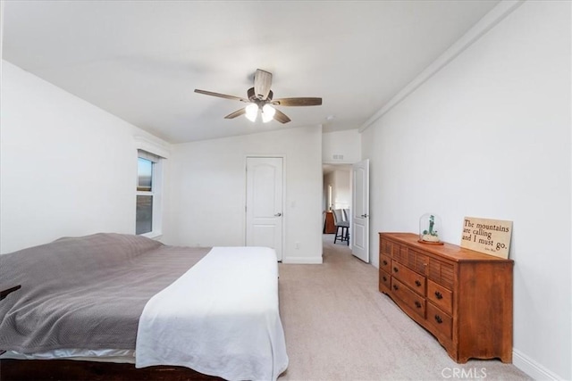 bedroom with vaulted ceiling, light carpet, ceiling fan, and baseboards