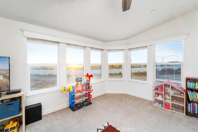 playroom with lofted ceiling, light carpet, and baseboards