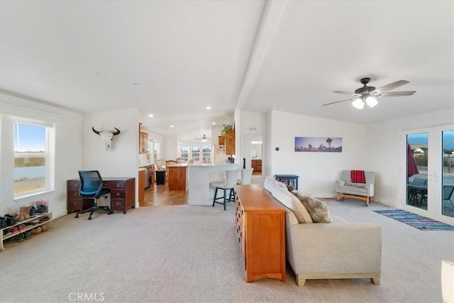 living area featuring light carpet, plenty of natural light, a ceiling fan, and vaulted ceiling with beams