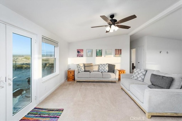 living area featuring a ceiling fan, lofted ceiling, light carpet, and baseboards