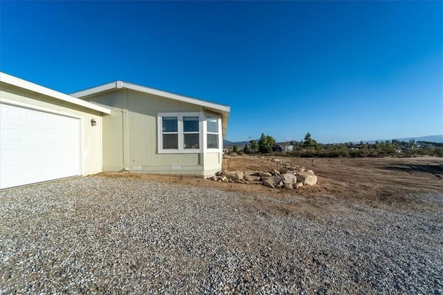 view of side of home featuring crawl space, driveway, and an attached garage