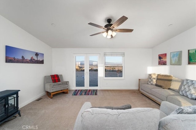 living room with a ceiling fan, lofted ceiling, french doors, and light carpet