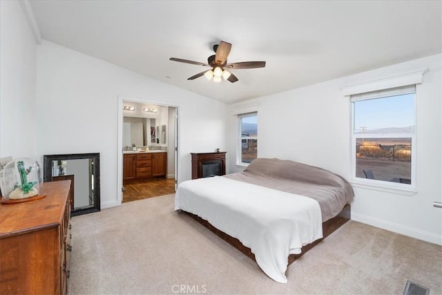 bedroom with lofted ceiling, light colored carpet, visible vents, and baseboards