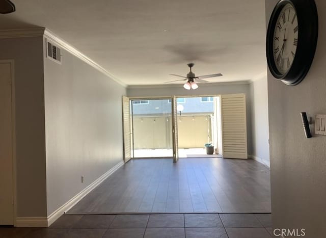 spare room featuring tile patterned flooring, visible vents, baseboards, a ceiling fan, and ornamental molding