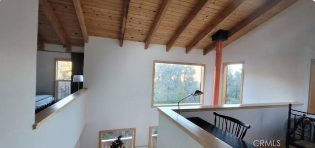 hallway with wood ceiling, an upstairs landing, and vaulted ceiling with beams