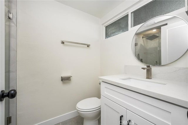 bathroom with a shower stall, vanity, toilet, and baseboards