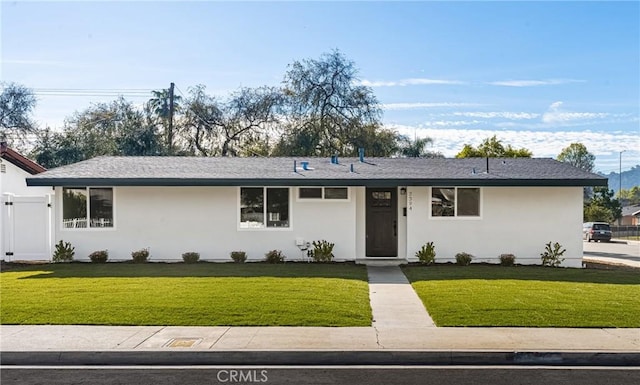 ranch-style house featuring a front yard and stucco siding