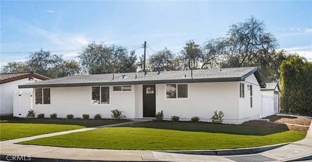 ranch-style home with a front yard and stucco siding