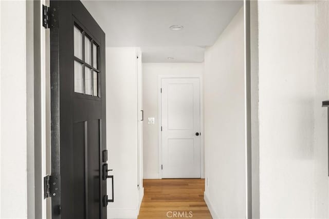 hallway with baseboards and light wood-style floors