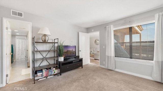 interior space with baseboards, visible vents, and light colored carpet