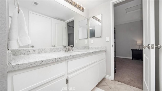 bathroom with visible vents, vanity, baseboards, and tile patterned floors