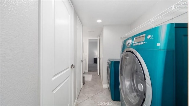 laundry room with washer and dryer, laundry area, and light tile patterned floors