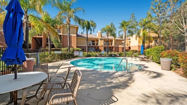 pool featuring a patio area, a residential view, and fence