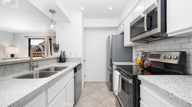 kitchen with stainless steel appliances, pendant lighting, white cabinets, and a sink