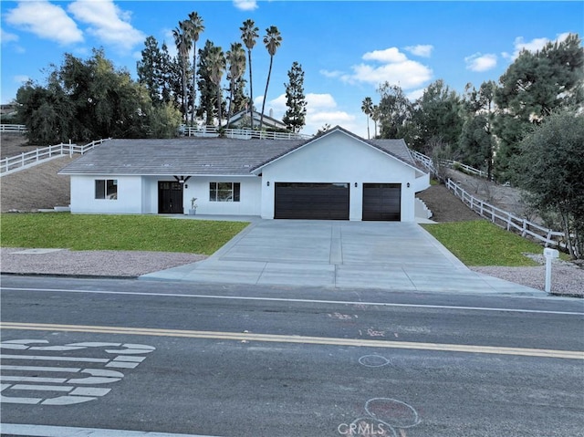 single story home featuring stucco siding, an attached garage, a front yard, and fence