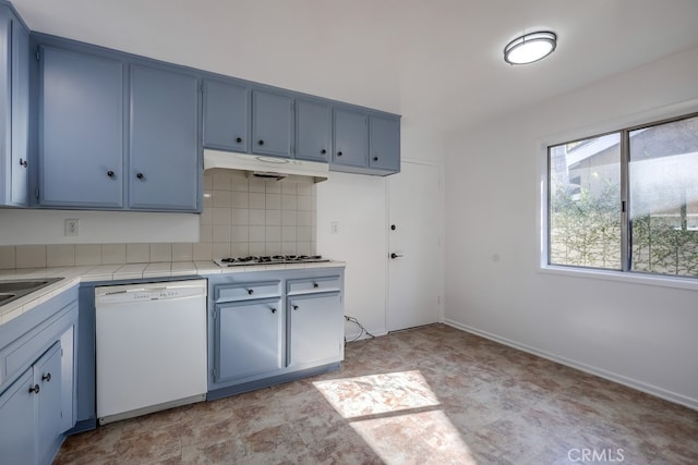 kitchen featuring stainless steel gas cooktop, white dishwasher, under cabinet range hood, and blue cabinetry