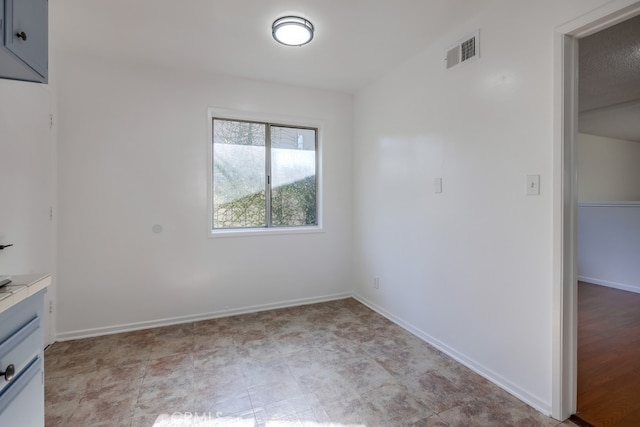 unfurnished room featuring baseboards and visible vents