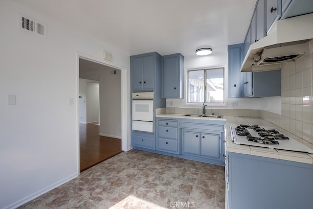 kitchen featuring under cabinet range hood, white appliances, a sink, visible vents, and a warming drawer