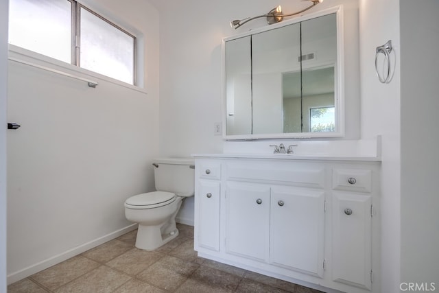 bathroom featuring a wealth of natural light, visible vents, vanity, and toilet