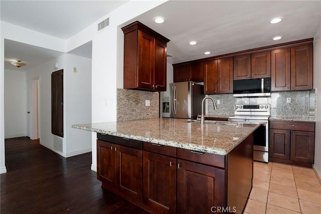 435 S La Fayette Park Pl Unit 311, Los Angeles, CA 90057 - kitchen featuring appliances with stainless steel finishes, a sink, a peninsula, light stone counters, and tasteful backsplash