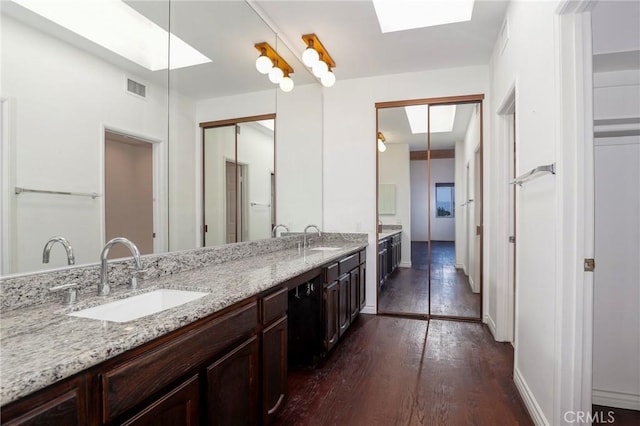 435 S La Fayette Park Pl Unit 311, Los Angeles, CA 90057 - bathroom featuring a skylight, hardwood / wood-style flooring, double vanity, and baseboards