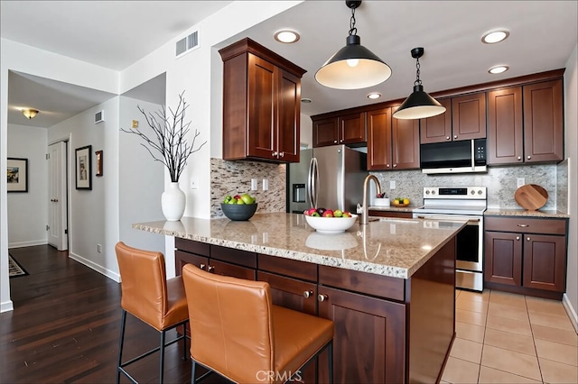435 S La Fayette Park Pl Unit 311, Los Angeles, CA 90057 - kitchen with appliances with stainless steel finishes, a peninsula, light stone counters, tasteful backsplash, and recessed lighting