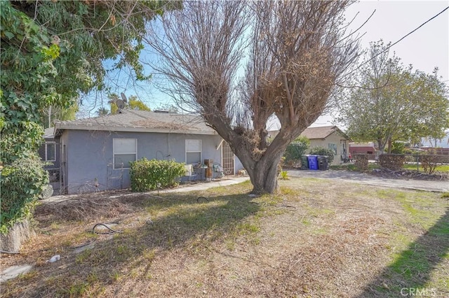 view of front of home featuring fence, a front lawn, and stucco siding