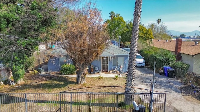 view of front of house with stucco siding, fence, driveway, and a mountain view