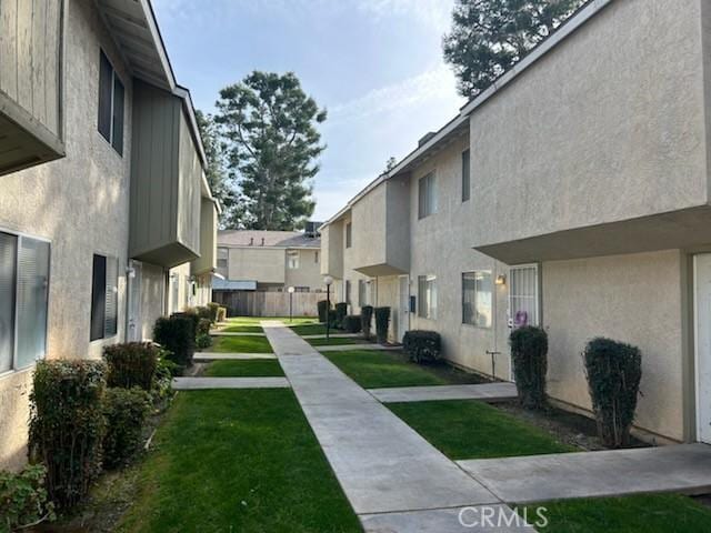 view of home's community featuring a residential view, a yard, and fence