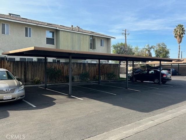 covered parking lot featuring fence