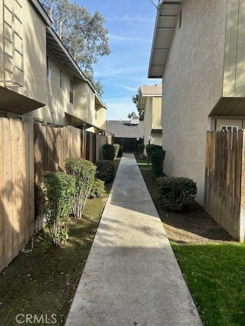 view of side of home with fence and stucco siding