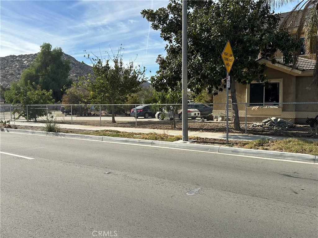 view of street featuring sidewalks, traffic signs, a mountain view, and curbs