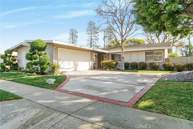 view of front of home featuring stucco siding, an attached garage, concrete driveway, and a front lawn