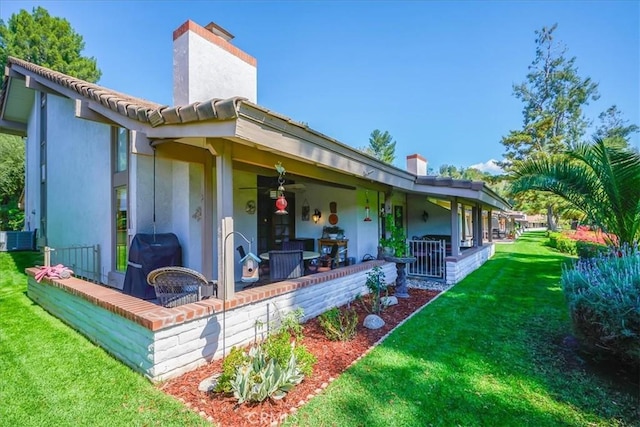 712 Via Zapata, Riverside, CA 92507 - rear view of house with a chimney, a lawn, covered porch, stucco siding, and cooling unit