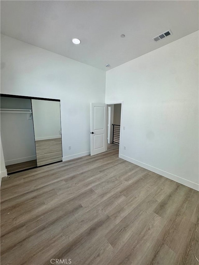 unfurnished bedroom featuring recessed lighting, visible vents, baseboards, light wood-style floors, and a closet