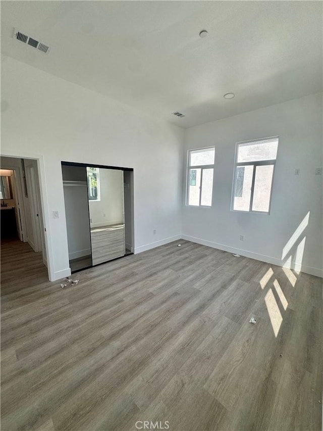 interior space with a closet, baseboards, visible vents, and light wood finished floors