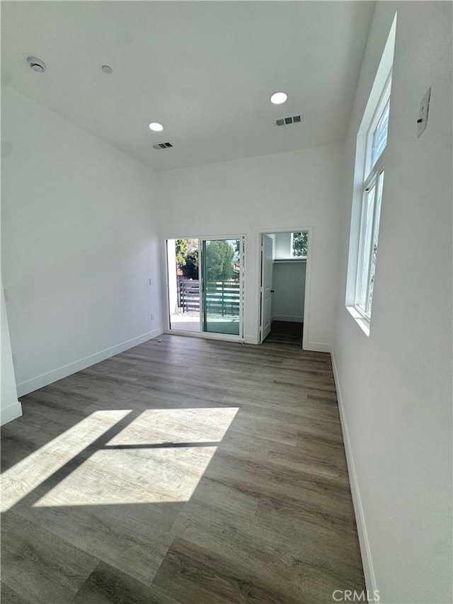 unfurnished room featuring dark wood-style floors, baseboards, visible vents, and recessed lighting