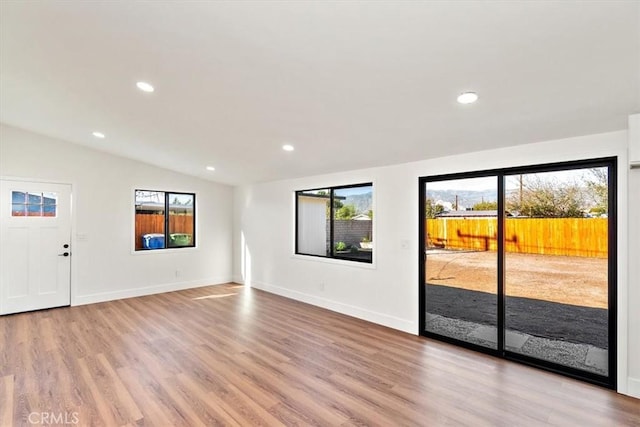 interior space with lofted ceiling, light wood finished floors, and recessed lighting