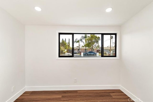 spare room featuring dark wood-style floors, recessed lighting, and baseboards