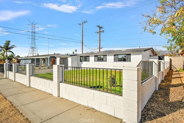 view of front of house featuring a fenced front yard, a front yard, a gate, and stucco siding